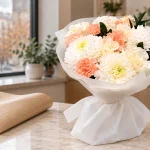 Букет «Персиковый фарфор» рядом с бумагой для перевозки в холодную погоду